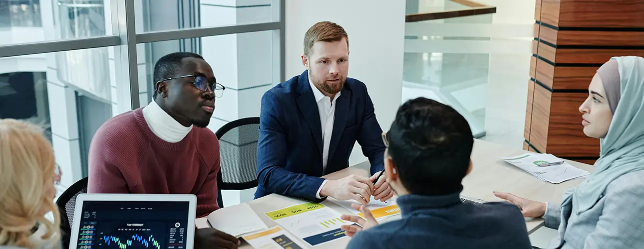 Confident business team collaborating in a modern office, symbolizing why businesses choose Softhealer for reliable, customized Odoo ERP solutions and expert support