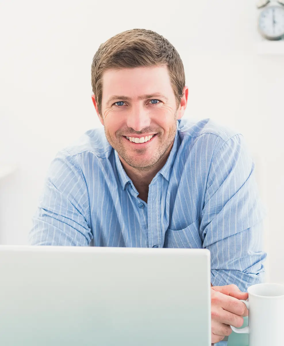 Smiling businessman at desk with coffee mug – symbolizing professionalism and productivity